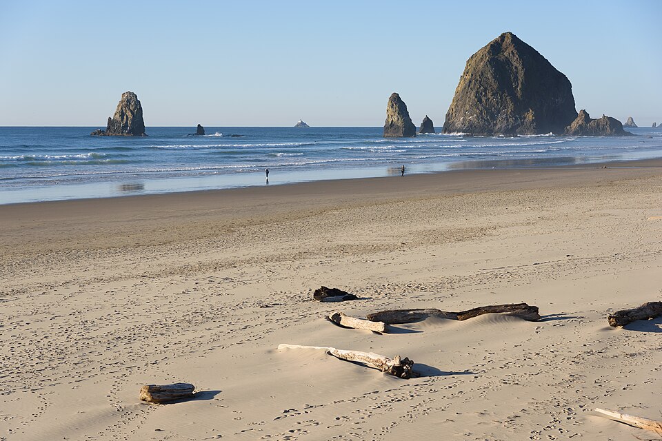 Sunny day on the wide sandy beach at Cannon Beach, Oregon, with Haystack Rock